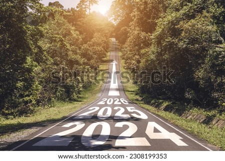 New year 2024 or straight forward concept. Text 2024, 2025, 2026 written on the road in the middle of asphalt road with at sunset. Concept of planning, goal, challenge, new year resolution.
