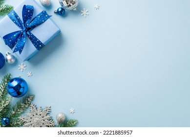 New Year celebration concept. Top view photo of blue silver baubles disco ball big giftbox with ribbon bow snowflake ornament fir branch and confetti on isolated light blue background with empty space - Powered by Shutterstock