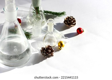new year in the chemical laboratory. holidays at work. chemical dishes on the table with cones, Christmas tree, Christmas toys, garland. - Shutterstock ID 2215441115