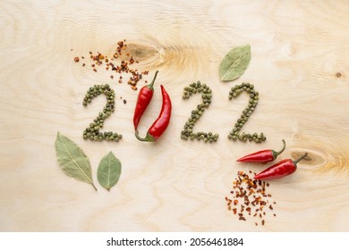 New year and christmas concept. Text 2022 made of pepper on wooden background, top view - Shutterstock ID 2056461884