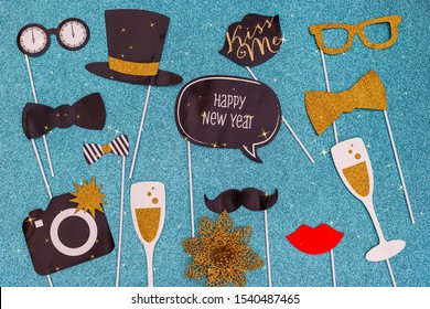 New Year and Christmas decorative paper Party accessories for photo shoots, top view. Photo booth props decorations Happy new year on blue glitter wrapping paper background. - Powered by Shutterstock