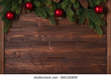 New Year and Christmas mockup with fir tree branches and red and golden decorations on the wooden background with copy space in the bottom - Powered by Shutterstock