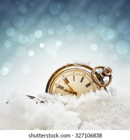 New year clock before midnight. Antique pocket watch in the snow