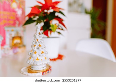 New Year composition with white decorative candlestick Christmas tree decorated with golden stars, on the background of red Christmas flower poinsettia, holiday atmosphere - Powered by Shutterstock