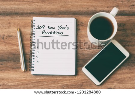 New year Concept - 2019 number and text on notepad. Smartphone, pen and cup of copy background. 