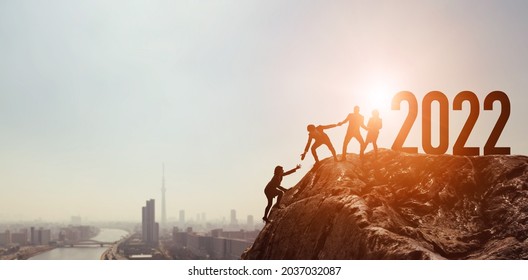 New year concept of 2022. Group of people climbing mountain. New year card.