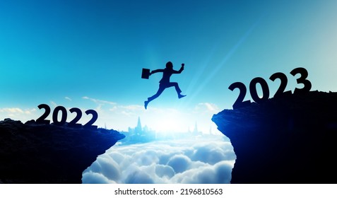 New year concept of 2023. New year's card. Silhouette of a man jumping over a cliff. - Shutterstock ID 2196810563