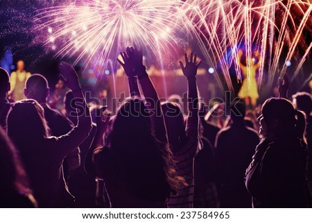 New Year concept - cheering crowd and fireworks 