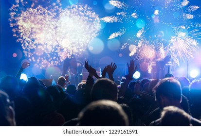 New Year concept - fireworks and cheering crowd celebrating the New year - Shutterstock ID 1229161591