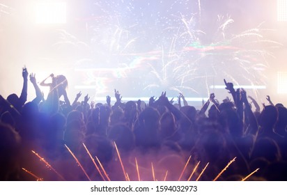 New Year concept - fireworks and cheering crowd celebrating the New Year - Shutterstock ID 1594032973