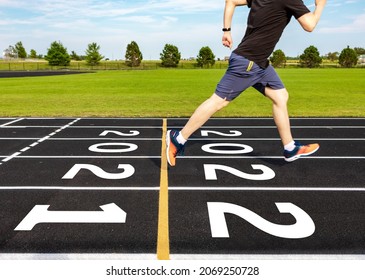 New Year Concept With Motion Blurred Of Man Running Overcome Year 2021 To 2022 At Black Running Track, Selective Focus On Numbers. Ideas Of Passing Old Year To New Year. Racing And Success Conceptual.