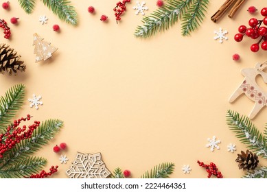 New Year concept. Top view photo of wooden ornaments fir branches in frost pine cones cinnamon sticks mistletoe berries and snowflakes on isolated beige background with blank space in the middle - Powered by Shutterstock