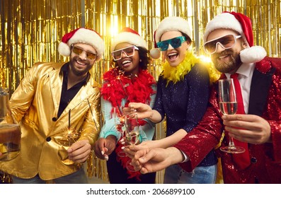 New year eve winter holiday celebration. Happy smiling friends merry christmas disco people group in party santa claus hat holding sparklers, xmas wine glasses posing for camera on glitter background - Powered by Shutterstock