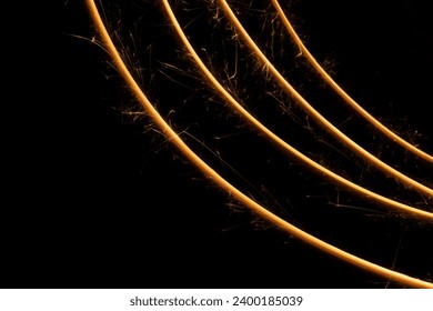 New Year festive abstract background with curved sparkler with sparkles as stripes on black background, copy space, pattern. Christmas, glowing line of burning fire for design, poster, card, flyer. - Powered by Shutterstock