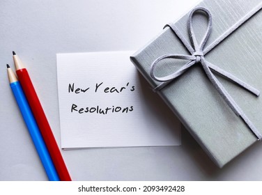 New Year Gift Box, Pencil And Note With Handwritten Text NEW YEAR'S RESOLUTIONS - A Self Promise To Start Doing Something Good, Make Life Better, Or Stop Bad Habits In The Next Coming New Year