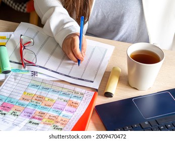 New Year Goals And Action Plan. Office Desk With Laptop And Year At A Glance Calendar For Planning Appointments, Important Events And Task Management. Woman Hand With Pen, Calendar And Coffee Cup