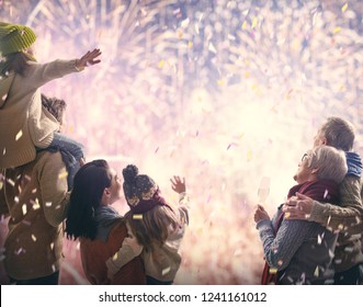 New Year Holiday. Parents And Daughters Children Girls Are Watching Fireworks. Happy Family On Snowy Winter Walk In Nature. Holidays Winter Season.