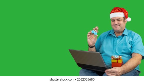 New Year Holiday video chat. man in Santa hat sitting at home on Christmas Day, video calling family. guy shows gifts to the laptop screen. Virtual Christmas house party. green background, chroma key - Powered by Shutterstock