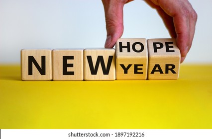 New year and hope symbol. Businessman turns cubes and changes the words 'new year' to 'new hope'. Beautiful white and yellow background. Copy space. Business and new year - hope concept. - Shutterstock ID 1897192216