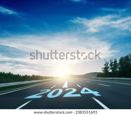 New year number 2024 and arrow sign on asphalt car road against blue sky