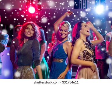 New Year Party, Holidays, Celebration, Nightlife And People Concept - Smiling Friends Dancing In Club And Snow Effect