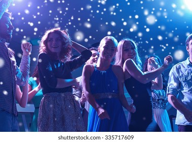 new year party, holidays, celebration, nightlife and people concept - group of happy friends dancing in night club and snow effect - Powered by Shutterstock