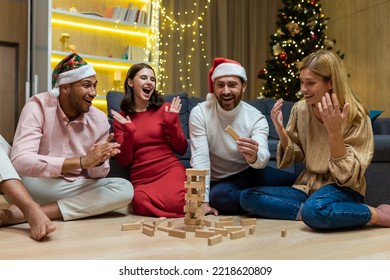 New year party, various friends at home on floor playing game, men and women smiling and happy together for christmas spend time. - Shutterstock ID 2218620809