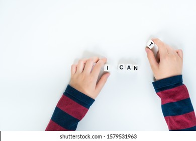 New year resolution 2021, confidence and self esteem concept. Hands of a young child removes a plastic cube with letter "T" from the word "I can't" to "I can". Beautiful top view shot with copy space.