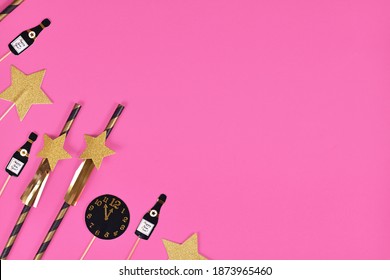 New Year Silvester Celebration Flat Lay With Golden, Black And White Striped Paper Stars And Champaign Flute And Clock Paper Decoration On Pink Background With Copy Space 