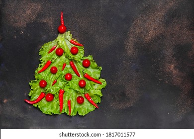 New Year Symbol: Xmas Tree Made From Fresh Green Salat Leaves, Cherry Tomatoes And Red Hot Chilli Peppers On Dark Background. Culinary Christmas Card With Space For Text Top View