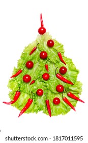 New Year Symbol: Xmas Tree Made From Fresh Green Salat Leaves, Cherry Tomatoes And Red Hot Chilli Peppers On White Background. Culinary Christmas Mock-up