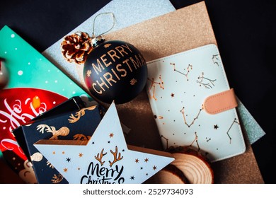 New Year toy with Christmas decorations, notepad, round wooden coasters, gifts and pine cone on a black wooden background. - Powered by Shutterstock