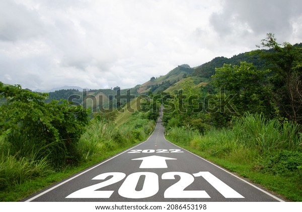 New year\
word 2021 to 2022 written on the road in the middle of asphalt\
road. Concept of planning and challenge or career path, business\
plan, strategy ,opportunity and change my\
life.