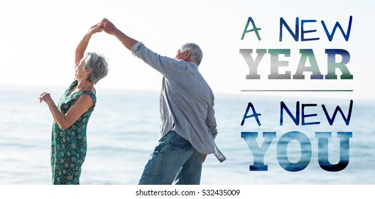 New Year New You Against Senior Couple Dancing At Beach