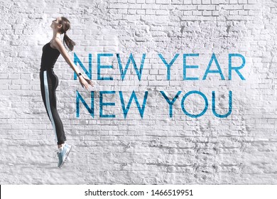 New Year New You - Inspirational Motivational Quote In The Form Of Graffiti On The Background Of An Old White Brick Wall. Comely Slim Young Energetic Woman Engaged In Fitness