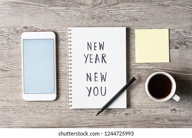 New Year New You Text On Notepad And Smart Phone, Pen And Coffee