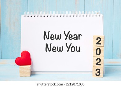 New Year New You words and 2023 cubes with red heart shape decoration on blue wooden table background. Goal, Resolution, health, Love and Happy Valentine’s day concept