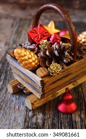 New Year's basket with Christmas-tree decorations and pine cones. Focus selective