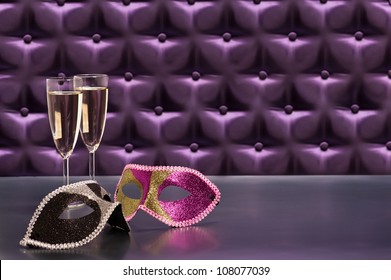 New Years Celebration Items In Front Of A Button Tufted Purple Silk Background