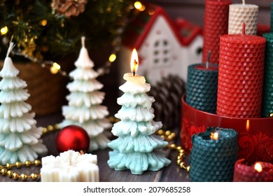New Year's composition with  candle in the shape of a Christmas tree,candles made of natural wax with texture of honeycomb bees, decor, garland, beeswax, red, golden, green