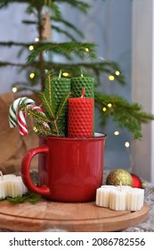 New Year's composition with  candles made of natural wax with texture of honeycomb bees, decor, garland, beeswax, red,  green, tree, cup