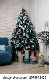 New Year's cozy home interior with a Christmas tree and garlands. the concept of decorating the living room in the house: pink and blue color of toys. artificial christmas tree. 