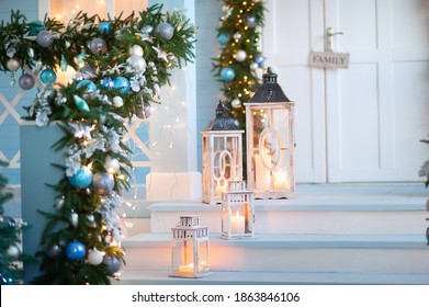 
New Year's decor in a blue veranda with a garland of blue, blue and gold balls. Great gifts, mailbox and Christmas tree. Decorative lanterns with candles - Powered by Shutterstock