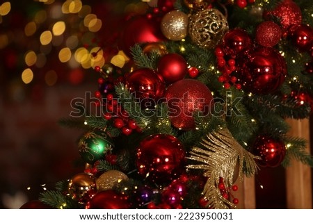New Year's decor, Christmas decoration at home. Decorated fir-tree with colorful balls, decorative garlands, lights, golden balls. Holiday ornament. Ornamental Christmas balls, Christmas macro photo