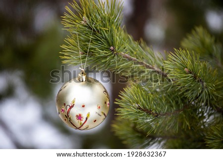 New Year's decoration hangs on a christmas tree in nature. High quality photo