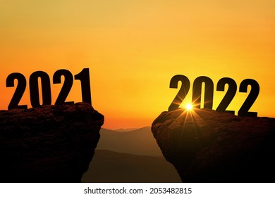 New Year's Eve 2022 on the mountain at sunset, concept. 2021 and 2022 on the cliff at sunrise, creative idea. Free space for design