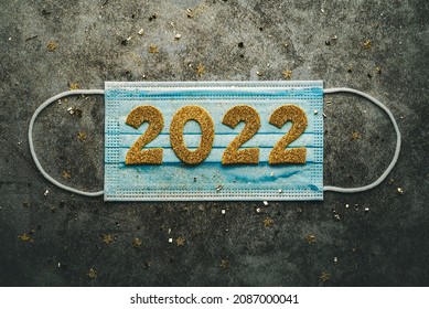 New Years Eve Celebration Concept Background.Medical Mask With The Numbers 2022 On Gray Background. Covid-19 New Year Concept 