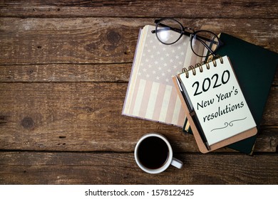 New Years Resolutions 2020 On Office Desk Table With Coffee Cup, American History Book, Pen, Notebook And Eyeglasses. Educations, Resolutions, Goal, Plan, Strategy, Politics Concept
