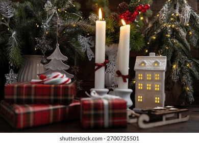 New Year's table setting with white candles and an elegant Christmas tree in the background. A festive and New Year's atmosphere.