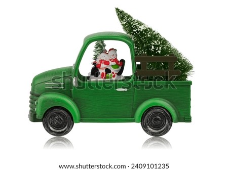 A New Year's toy, Christmas decoration for the house in the form of a green car with snowmen and a Christmas tree, isolated on a white background